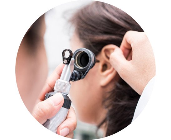 Woman receiving a professional hearing examination with an otoscope.