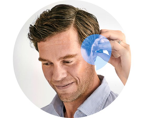 Man inserting a discreet hearing aid.