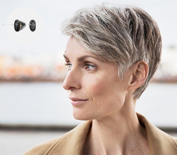 L'image montre une personne portant des appareils auditifs Audika 360