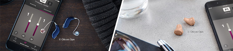 Hearing aids displayed next to a smartphone with a hearing aid control app showing adjustable settings.