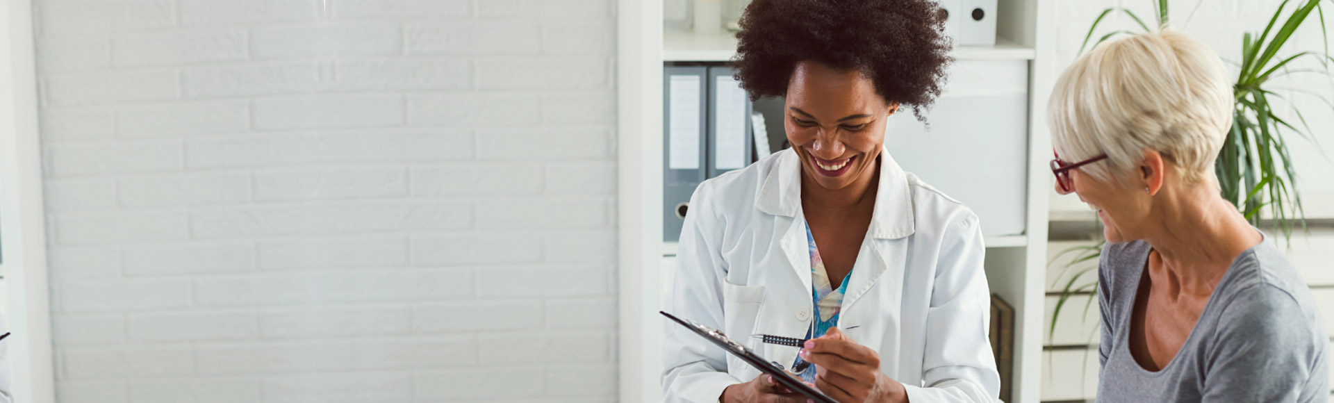 L’image montre une femme et un audioprothésiste qui regardent un iPad