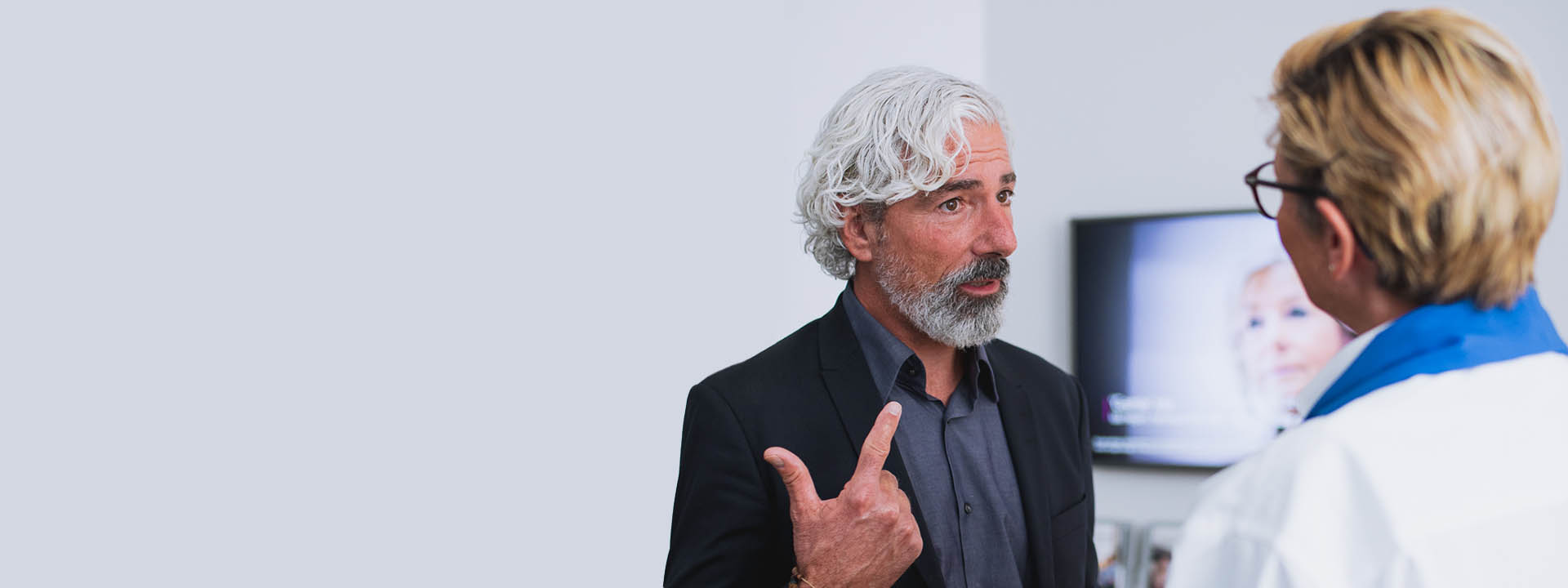 Man in gesprek met audicien in hoorwinkel.