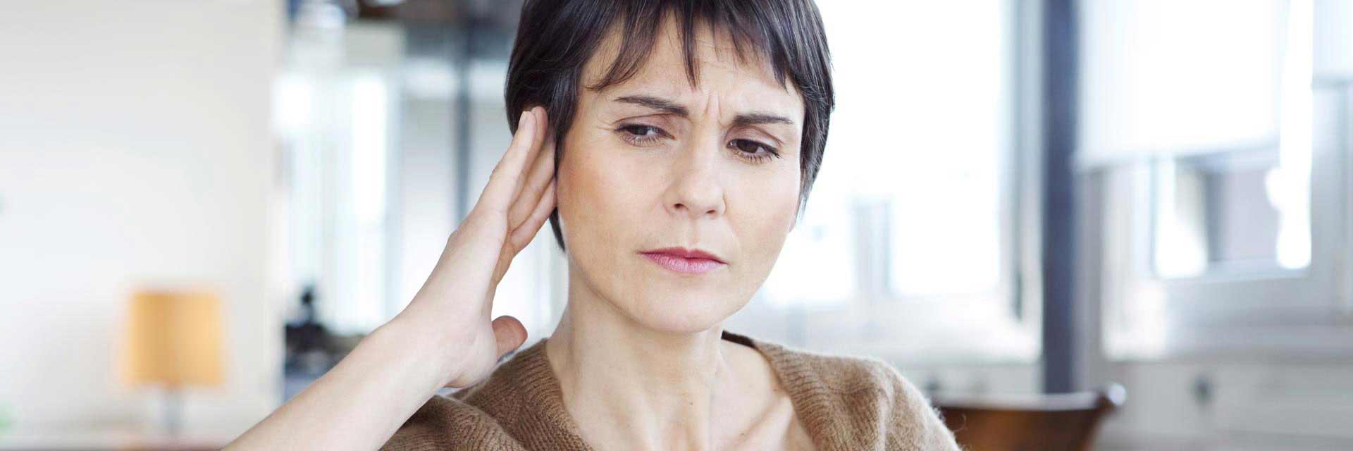 Image shows man talking to audiologist in the clinic