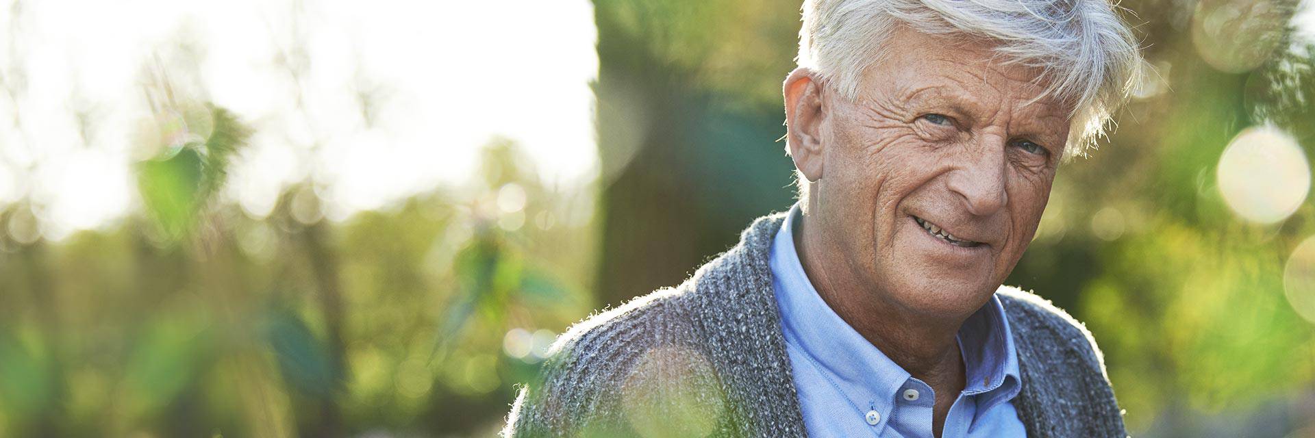 Image shows couple and audiologist looking at hearing aids 