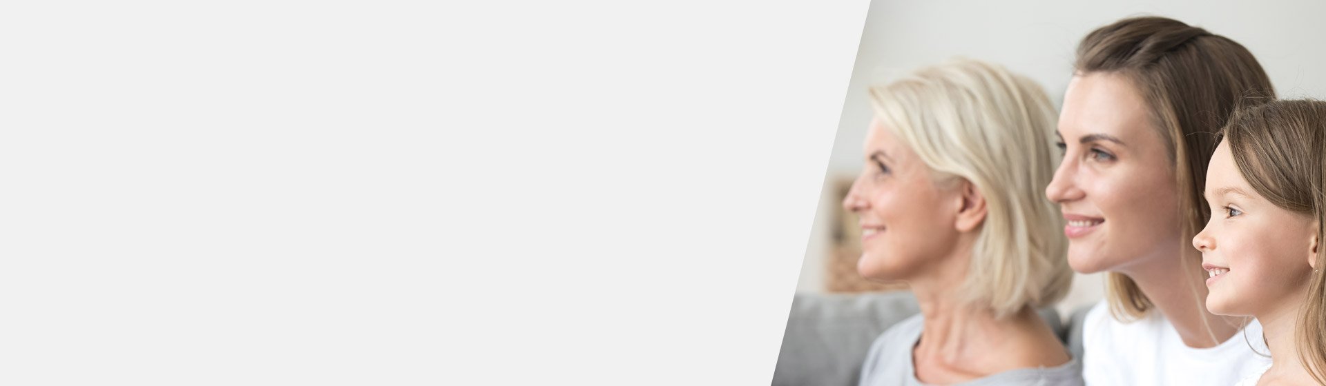 Tres generaciones de mujeres sentadas juntas, destacando la pérdida auditiva relacionada con la edad en la mujer mayor.