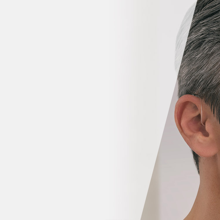 L’image montre un appareil auditif placé derrière l’oreille d’un homme.