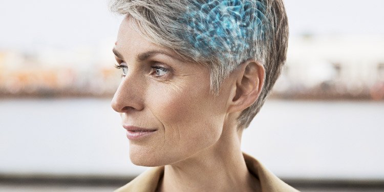 Kobieta z aparatem słuchowym umieszczanym za uchem.