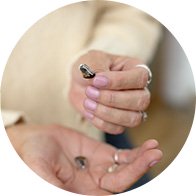 Hand holding a small modern hearing aid