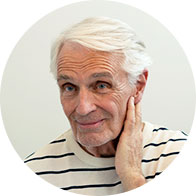 Image shows woman holding hand close to her ear