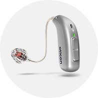 Oticon hoortoestel in zilverkleur met een discrete luidspreker en transparant oorstukje, geplaatst tegen een witte achtergrond. Ideaal voor gehoorzorg in een professionele hoorwinkel of kliniek.