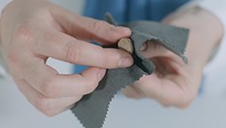 Limpieza de audífonos intracanal personalizados Audika con paño especializado