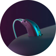 Modern hearing aid with sleek design and glowing indicator light placed against a dark gradient background.