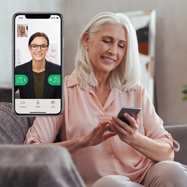 Donna anziana utilizza uno smartphone con un’applicazione per il controllo dell’audio degli apparecchi acustici.