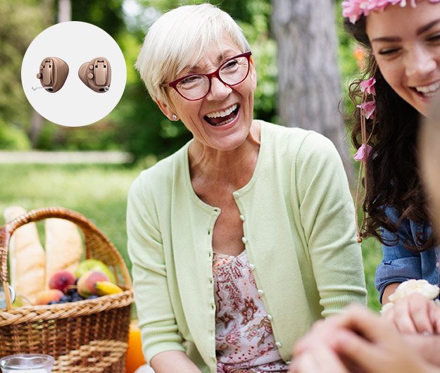 Billedet viser smilende kvinde og helt i ørekanalen høreapparater