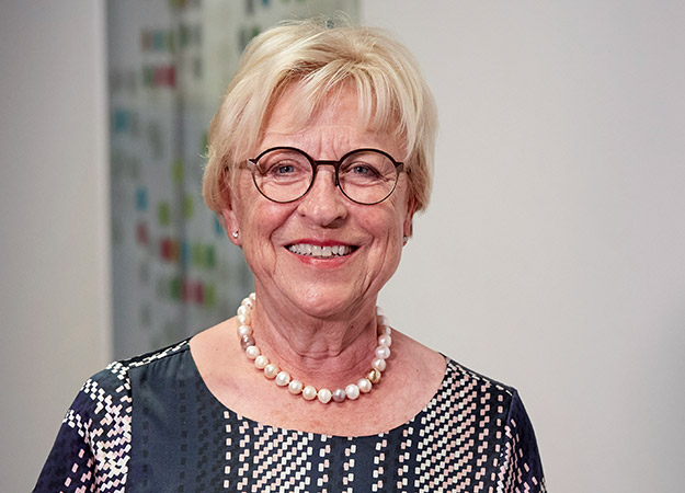 Glimlachende oudere vrouw met parelketting