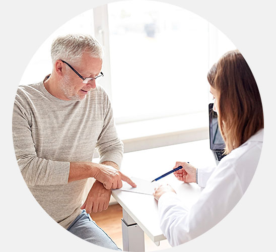 Senior man consulting with audiologist about hearing care solutions.