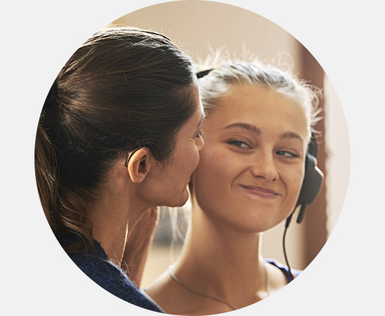 Image shows audiologist talking to woman in a hearing clinic