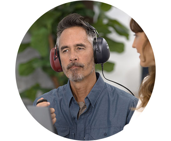 Une personne portant un casque effectue un test auditif avec une audioprothésiste.