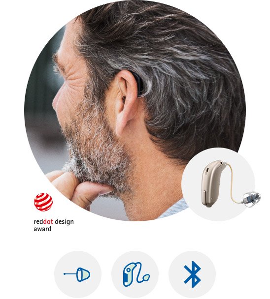 Mężczyzna noszący aparat słuchowy Oticon Opn™ z nagrodą Red Dot Design.