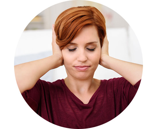 Woman covering her ears with both hands, appearing to block out noise.