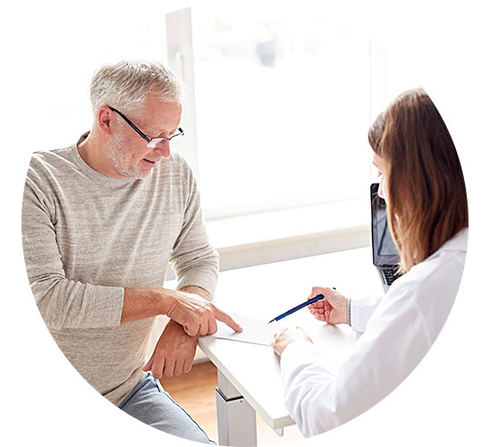 Un homme consulte une professionnelle de la santé qui explique un document.