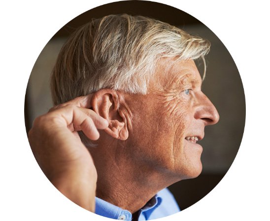 Mężczyzna w średnim wieku dotykający ucha, wskazujący na problemy ze słuchem.