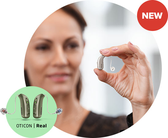 A hand holds an Oticon Real™ hearing aid, showcasing its sleek design. A 'NEW' label appears in the top right corner. Below, a green overlay highlights two Oticon Real™ devices.