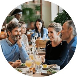 Drei Erwachsene unterhalten sich bei einem Restaurantbesuch