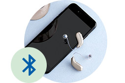 Bluetooth-Hörgeräte neben Smartphone mit Bluetooth-Symbol