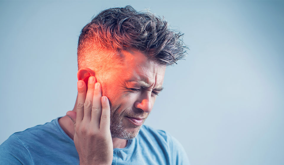 Image d'un homme qui met sa main sur son oreille