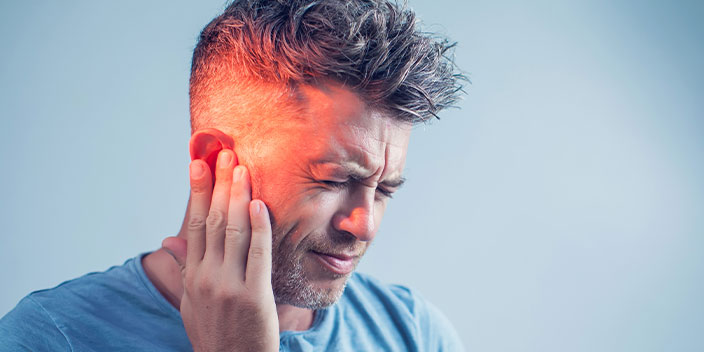 Image d'un homme qui met sa main sur son oreille