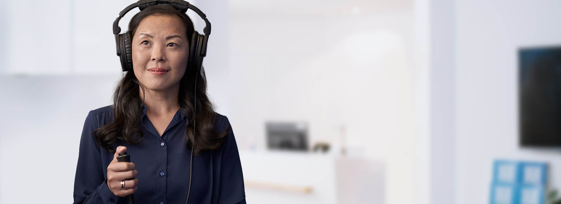 L’image montre une femme avec un casque sur les oreilles