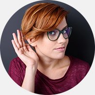 L’image montre une femme qui rapproche sa main de son oreille