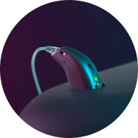 Appareil auditif moderne posé sur une surface, éclairé par une lumière violette et bleue.