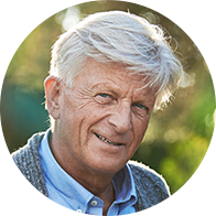 Homme senior aux cheveux gris profitant d’une promenade en plein air dans un environnement lumineux.