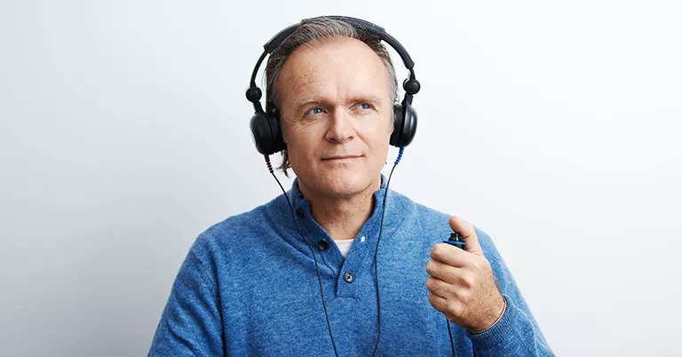 Test auditif avec casque et boîtier de réponse en main.