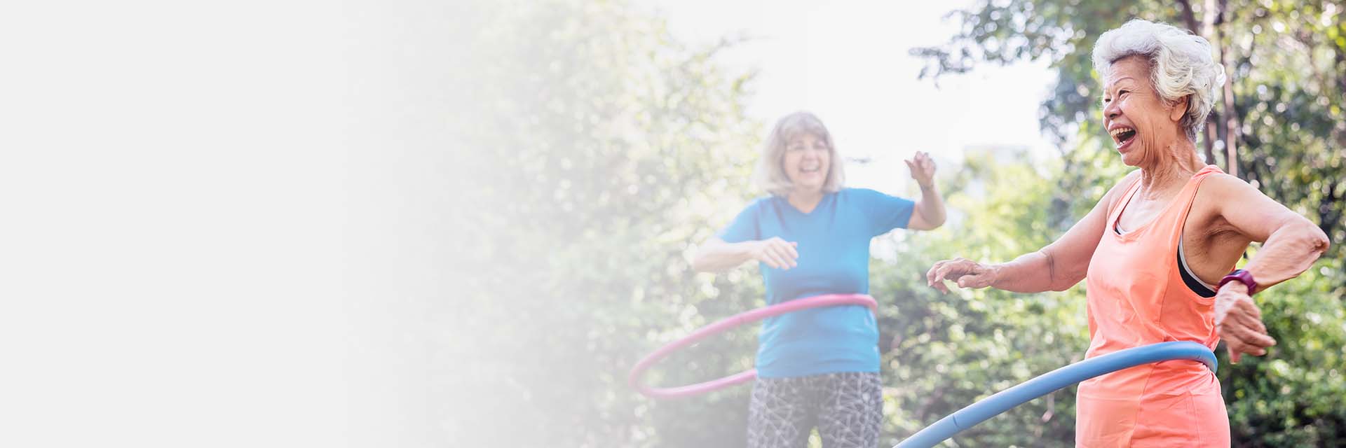 Oudere vrouw met gehoorapparaat die buiten hoepelt.