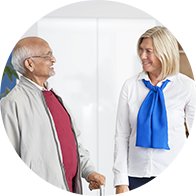 Man met seniorenstok en audioloog in gesprek in hoorcentrum