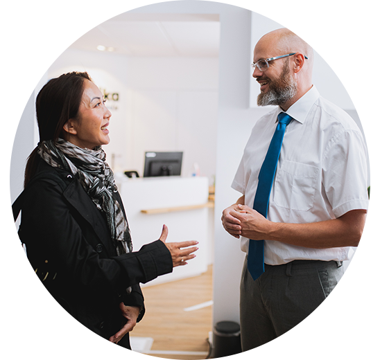 Audioloog in gesprek met een vrouw in een hoorcentrum.